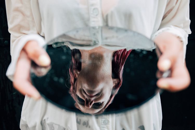 Midsection of woman holding mirror