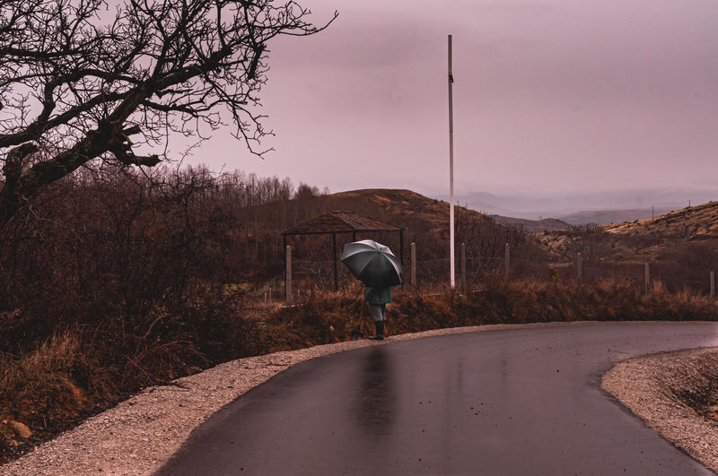 Closeup view of men and umbrella on empty road