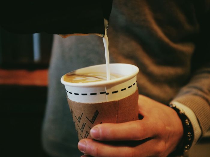 Cropped image of man pouring coffee in disposable cup
