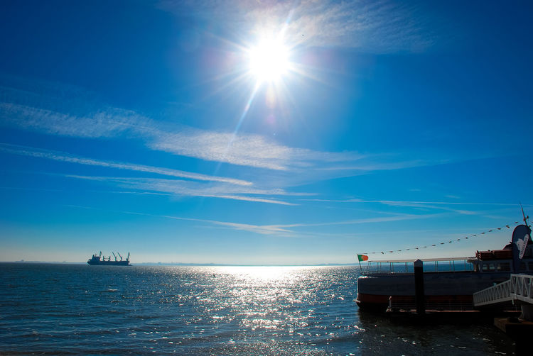Scenic view of boats in sea against blue sky