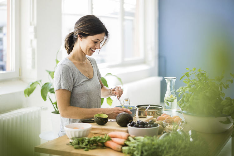 Midsection of woman having food at home