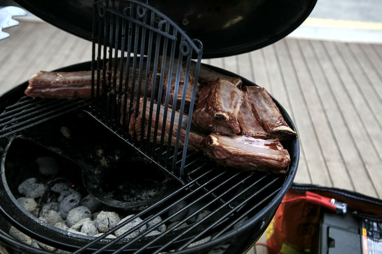 High angle view of beef ribs grilling on barbeque grill