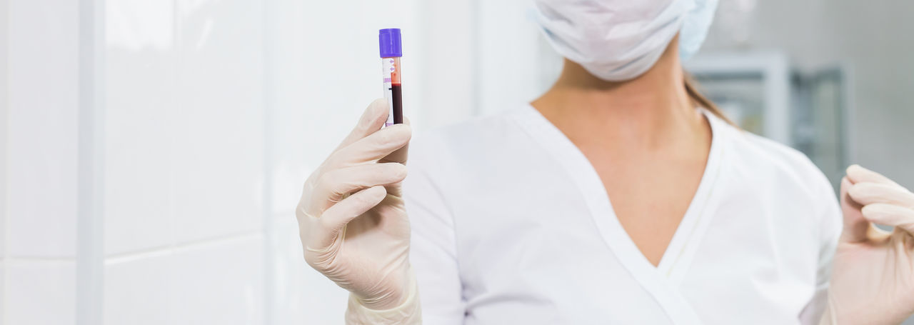 Midsection of doctor holding blood sample