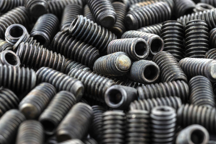 Background made from a macro shot of scattered, black grub screw on table.