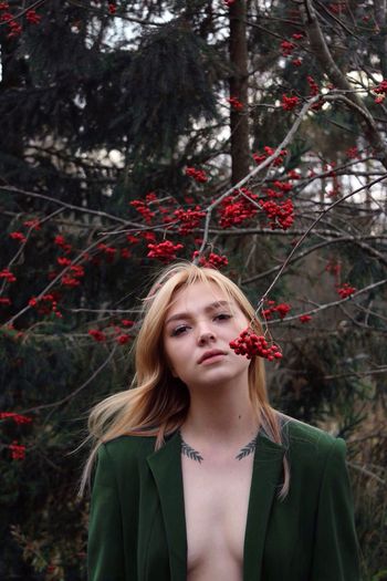 Beautiful young woman by tree with berries