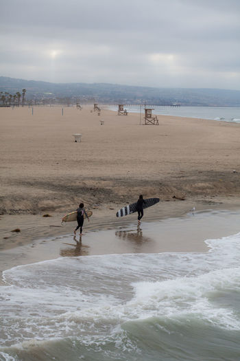 High angle view of people with surfboards walking at beach