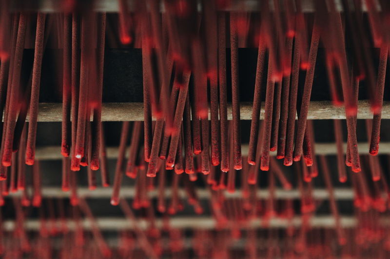 Full frame shot of red incense sticks hanging