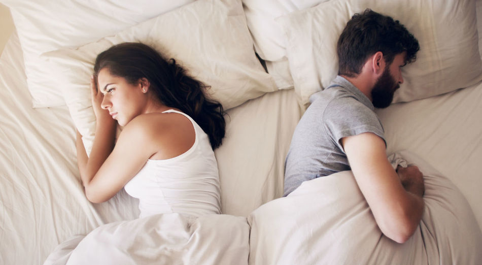 Sad couple lying on bed
