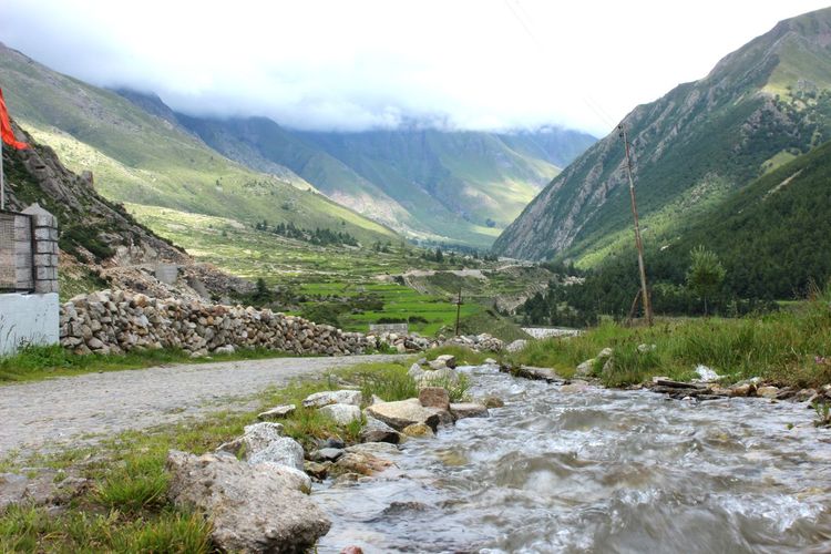 Scenic view of river by mountains against sky