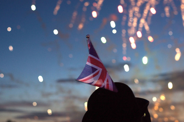 British flag in a hat against background of fireworks
