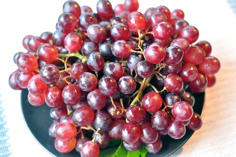 Close-up of grapes on table against white background