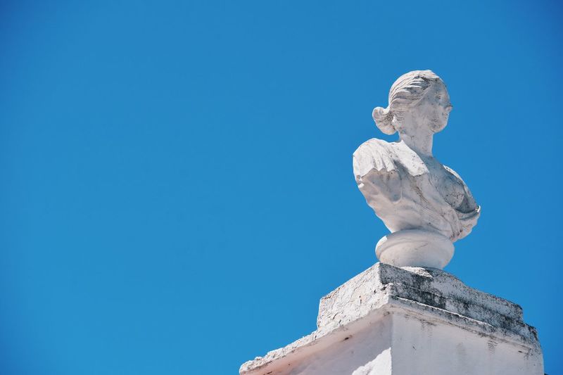 Low angle view of statue on column against clear sky