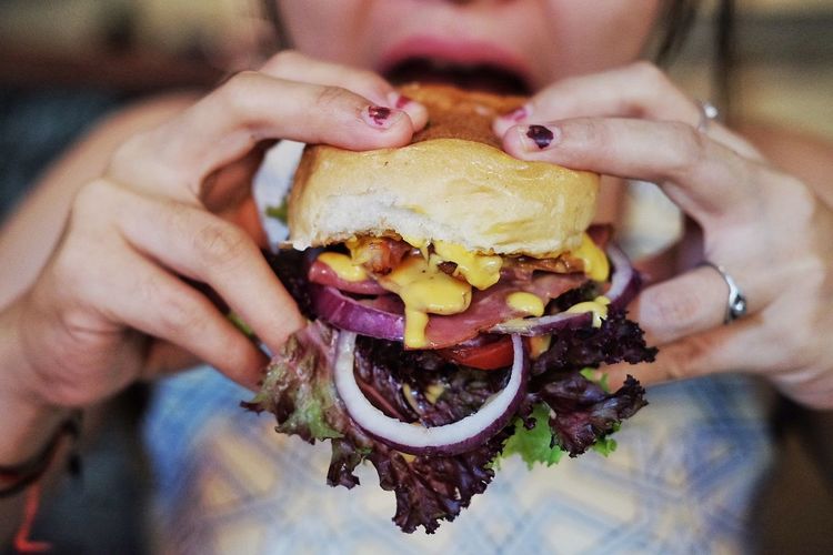 Midsection of woman having burger