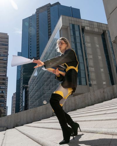 Low angle view of young woman exercising on street