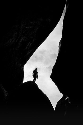 Silhouette man standing on rock