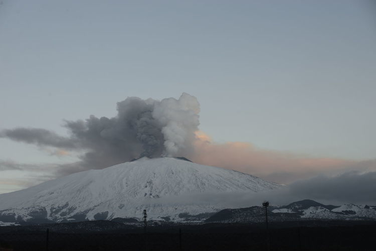 Scenic view of snowcapped mountains against sky etna eruption