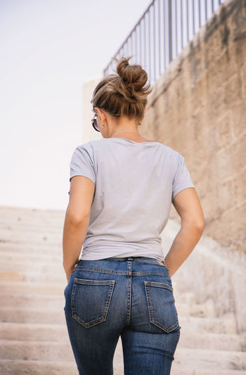 Young woman standing against wall