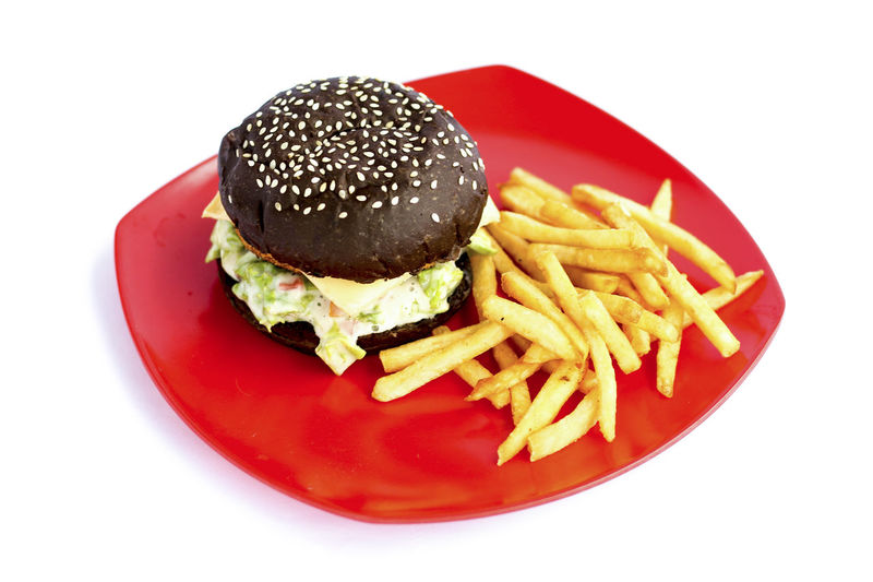 Close-up of burger in plate against white background