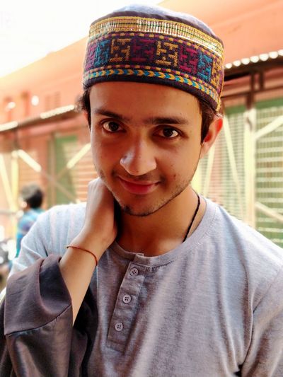 Close-up portrait of smiling young man wearing taqiyah