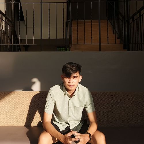 Young man sitting on staircase