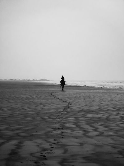 Man on beach against clear sky