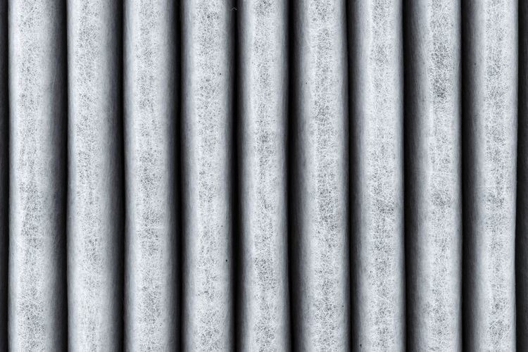 A macro shot of the surface rectangular, carbon cabin filter. fibers arranged in vertical lines.