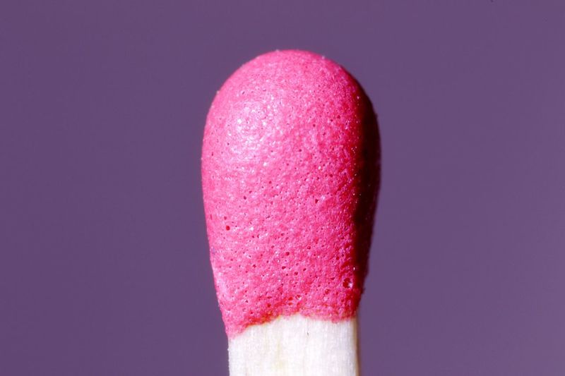 Extreme close-up of matchstick against purple background