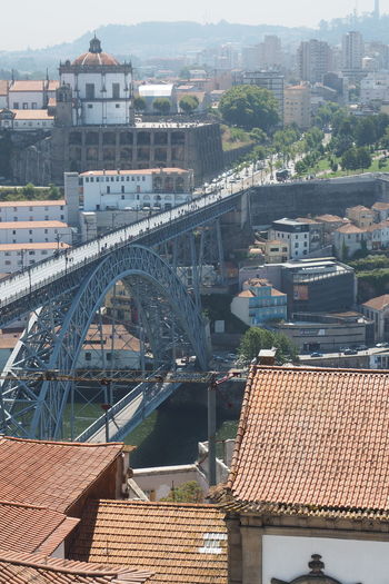 High angle view of arch bridge over river and buildings in city