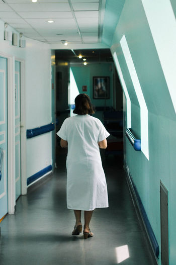 Rear view of woman standing in corridor