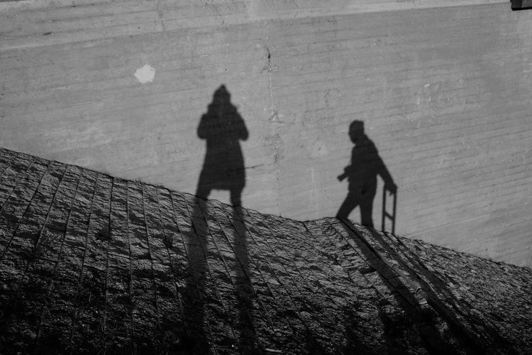 Shadow of people walking on wall