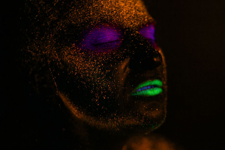 Woman with eyes closed in neon make-up