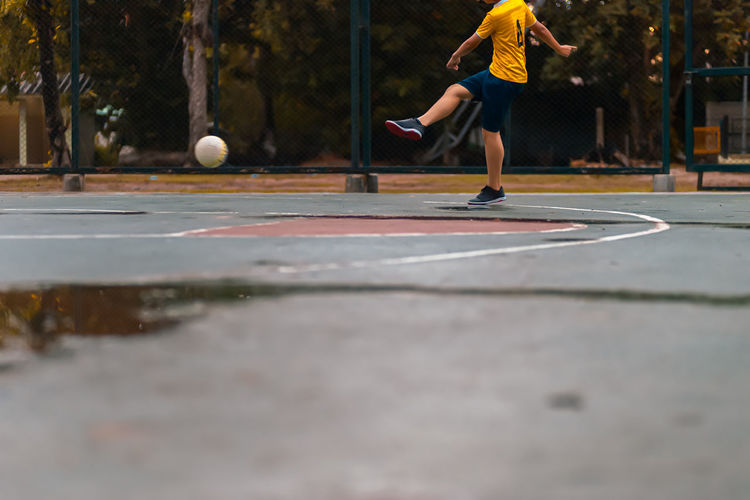 Low section of man playing football outdoors