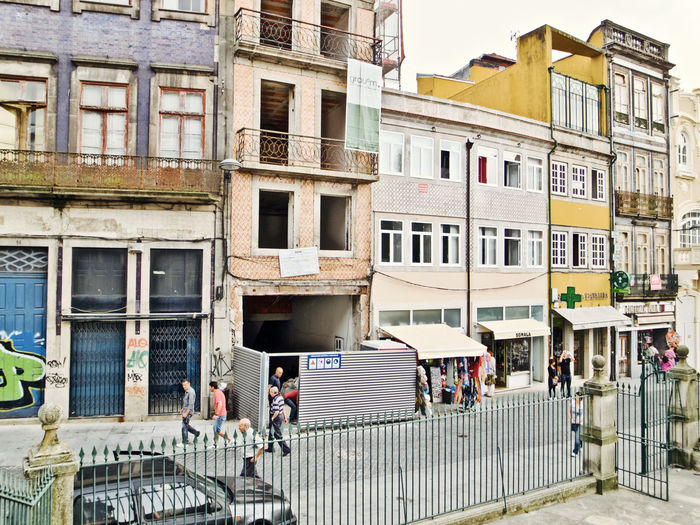 People on street against buildings in city