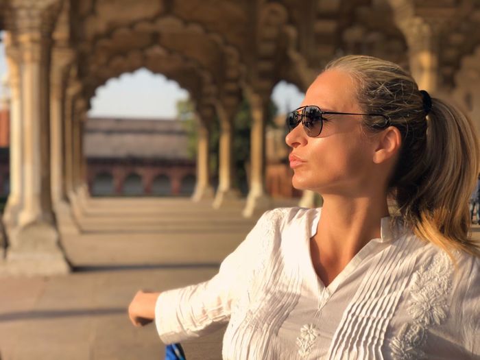 Woman wearing sunglasses standing in agra fort