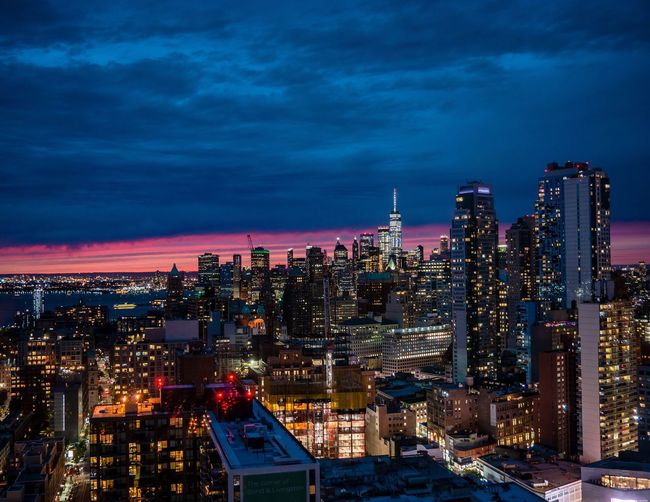 Illuminated buildings in city against sky at night