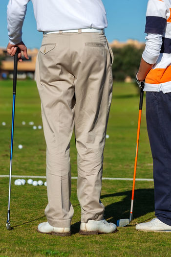 Low section of man standing on golf course