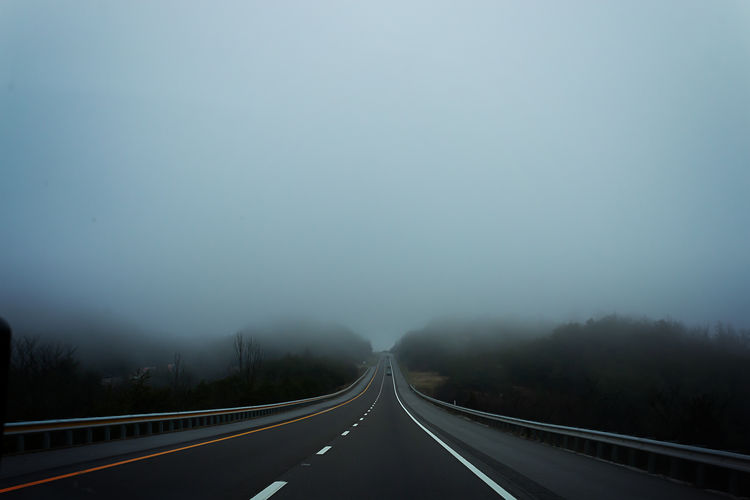 Highway against sky during foggy weather