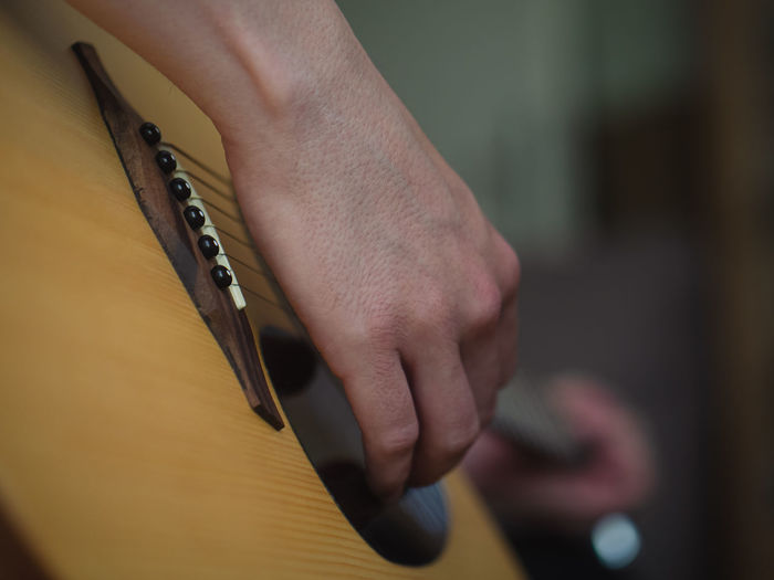 Cropped hand of woman playing guitar