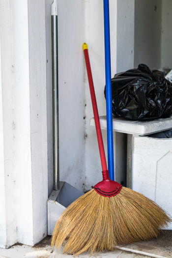 Close-up of broom and cleaning equipment against wall