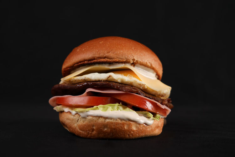 Close-up of burger against black background
