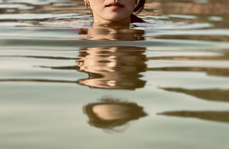 Low section of woman with reflection in water