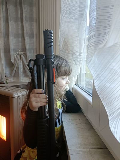 Midsection of ukrainian little girl with shotgun