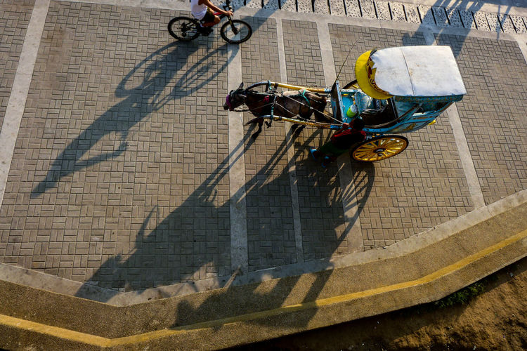High angle view of shadow of man on bicycle in city
