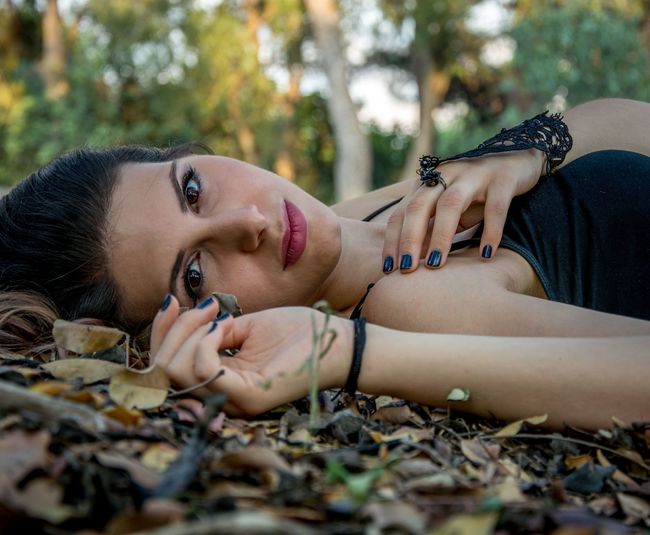 Portrait of beautiful young woman lying on field