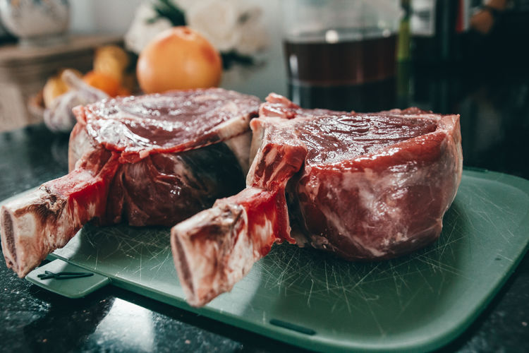 Raw rib eye steak on green cutting board