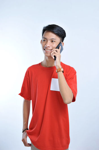 Portrait of a young student asian man talking on mobile phone, speak happy smile