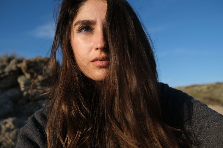 Portrait of beautiful woman against sky