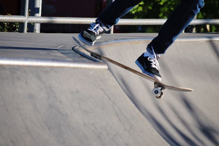 Low section of man skateboarding in park