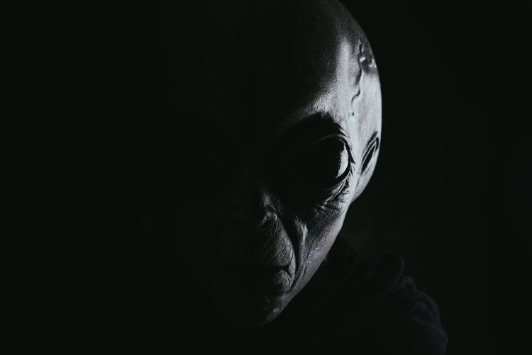 Portrait of alien against black background