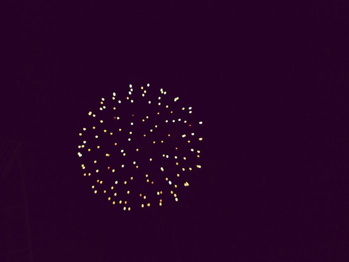 Close-up of illuminated firework over black background